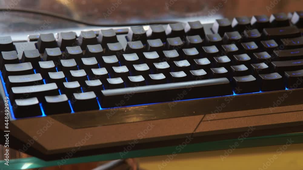 Hands typing of the keyboard with RGB backlight