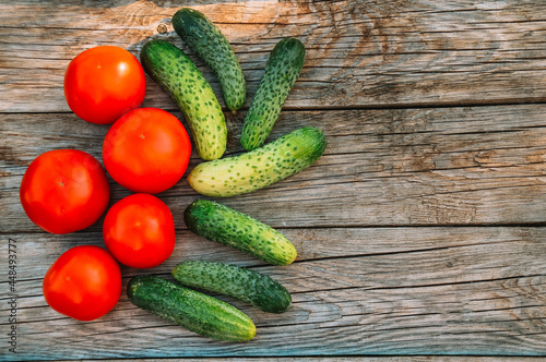 Cucumbers and tomatoes on a wooden background. Harvesting from the garden. Eco products. Farming