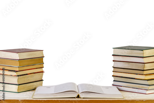 An open textbook and stacks of books on the reading desk. Learning concept. Isolated on white background