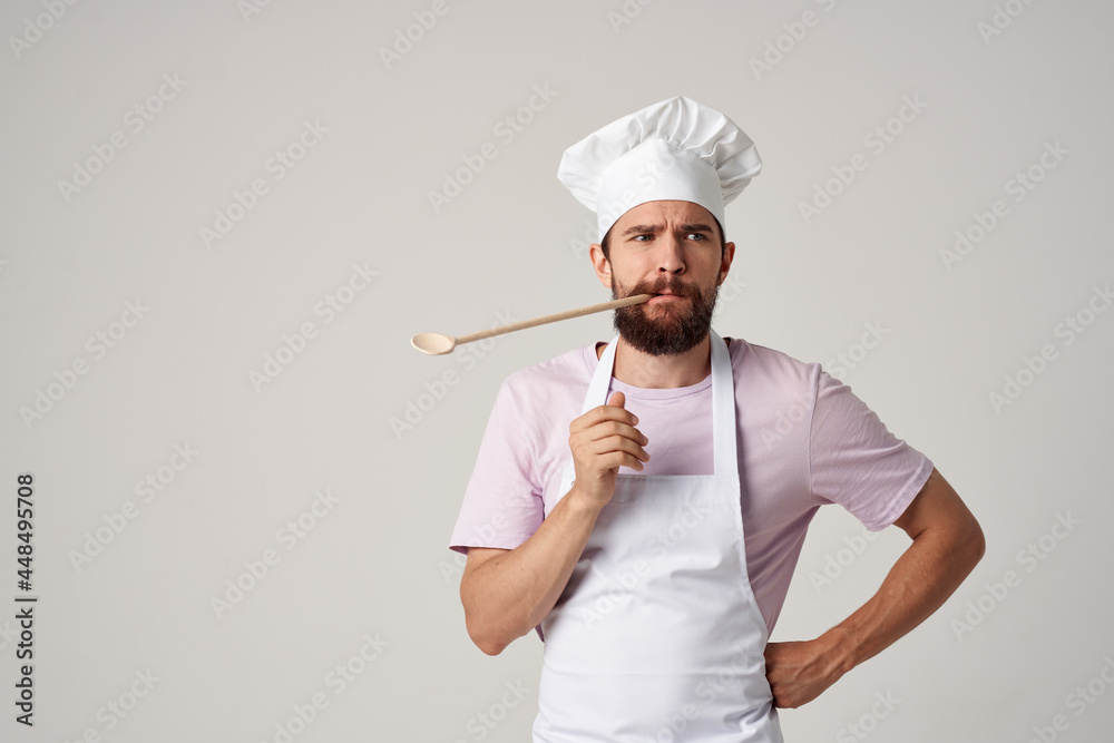 bearded male chef in uniform spoon in teeth working in a restaurant bearded male chef in uniform spoon in teeth working in a restaurant