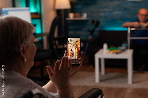 Photos Grandmother talking to family on internet video call using online smartphone technology at home
