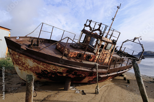 A rusty boat on the shore of the White Sea. The ship is stranded. North