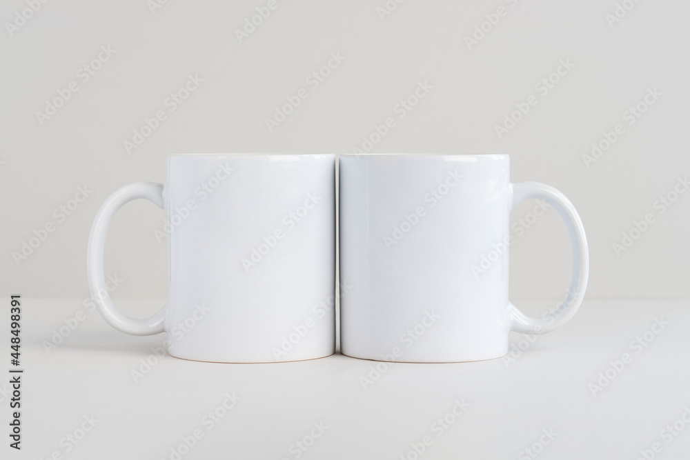 Two white mugs on light gray background, mockup Two white mugs on light gray background, mockup