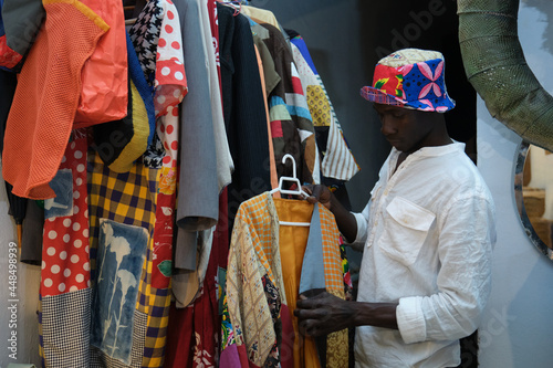 Black man choosing an african item of clothing to wear.