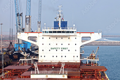 A large bulk carriers, tugboats at the port under cargo operations and underway. Close-up view of ships constructions and equipments. Gopalpur, India, November, 2020.