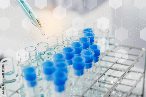 Biochemistry laboratory research, Scientist or medical in lab coat holding test tube with using reagent with drop of color liquid over glass equipment working at the laboratory.