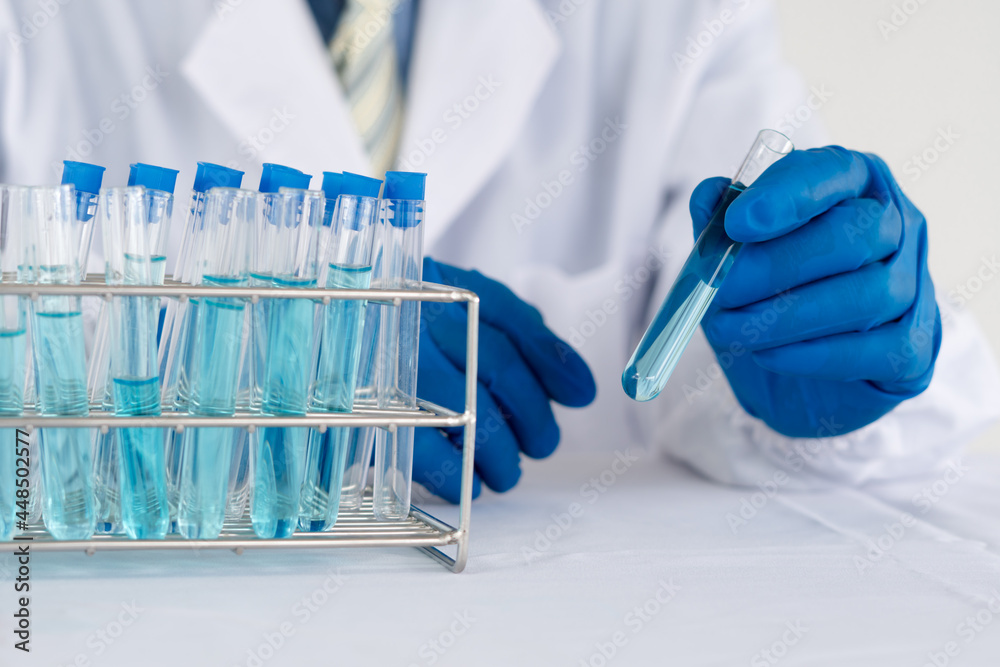 Doctor holding test tube with sample for analysis in laboratory, closeup Doctor holding test tube with sample for analysis in laboratory, closeup