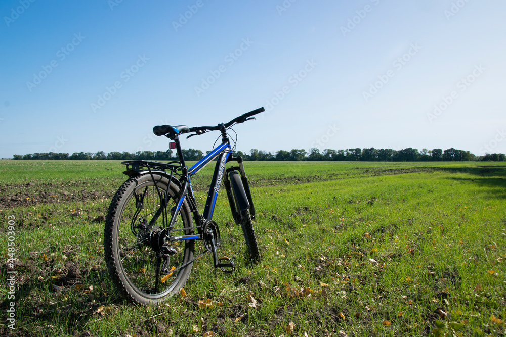 bike stands on in the field. A mountain bike stands on a field path with green grass. cycling. Mountain bike. outdoor cycling activities. space for text. editorial, Ukraine, Kiev region 2020