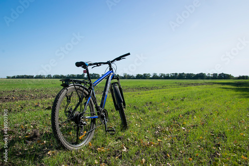 bike stands on in the field. A mountain bike stands on a field path with green grass. cycling. Mountain bike. outdoor cycling activities. space for text. editorial, Ukraine, Kiev region 2020