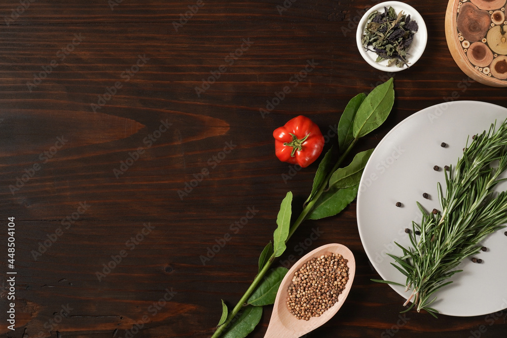 Assorted spices with fresh herbs on a wooden background. Natural food additives. Aromatic herbs and spices from garden, healthy cooking concept. Fresh lemon, tomato. Flat lay, top view Assorted spices with fresh herbs on a wooden background. Natural food additives. Aromatic herbs and spices from garden, healthy cooking concept. Fresh lemon, tomato. Flat lay, top view