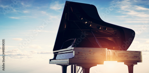 Grand piano on sunset sky background