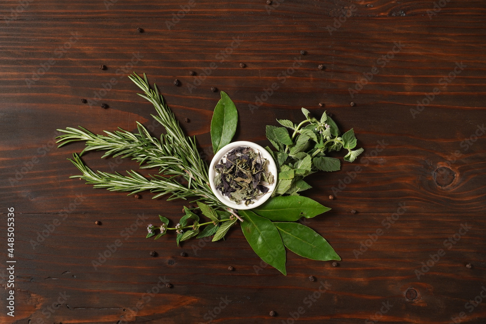 Assorted spices with fresh herbs on a wooden background. Natural food additives. Aromatic herbs and spices from garden, healthy cooking concept. Flat lay, top view Assorted spices with fresh herbs on a wooden background. Natural food additives. Aromatic herbs and spices from garden, healthy cooking concept. Flat lay, top view