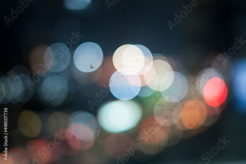 Bokeh lights on the rain look out the window .