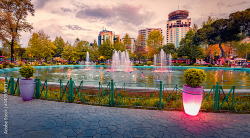 Spectacular spring view of Scanderbeg Square with illuminated fountain. Picturesque sunset in capital of Albania - Tirana. Traveling concept background.