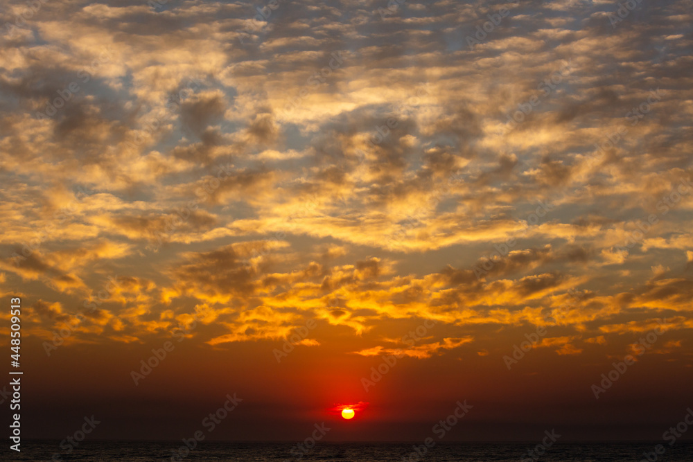 dramatic clouds and bright sunset over the ocean on an island dramatic clouds and bright sunset over the ocean on an island