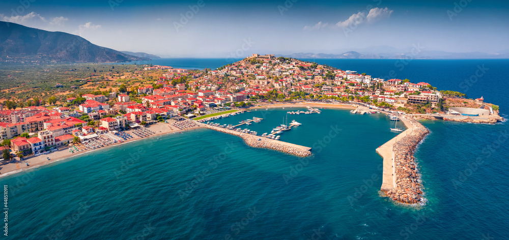 Panonoramic view from flying drone of Astros port. Sunny summer seascape of Myrtoan Sea. Aerial urban scene of Arcadia region, Greece, Europe. Traveling concept background.