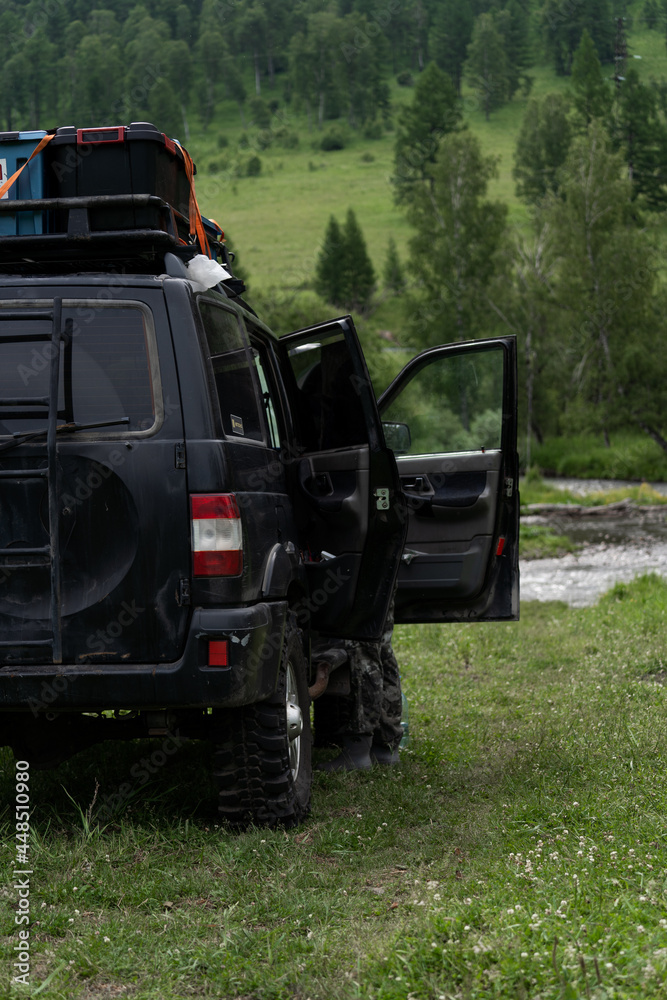 SUV with open doors against the backdrop of mountains. Expedition car for travel