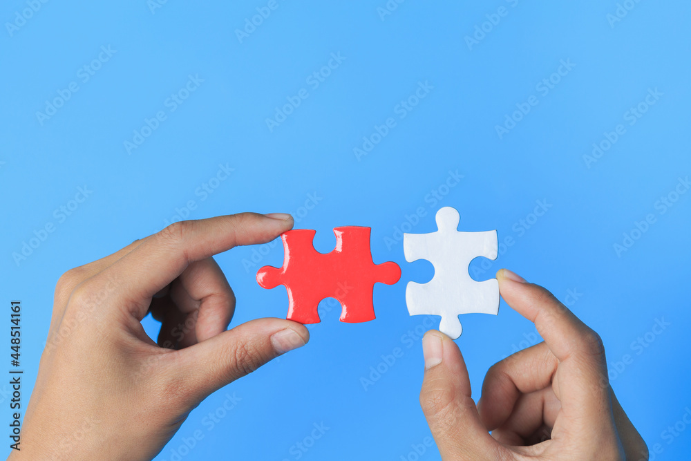 Business women connecting white and red jigsaw puzzles, , cooperation in decision making, team support in solving problems and corporate group teamwork concept. Business women connecting white and red jigsaw puzzles, , cooperation in decision making, team support in solving problems and corporate group teamwork concept.