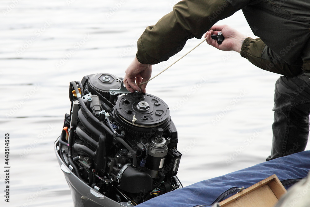 Boater hand start an outboard boat motor without the hood cap on the