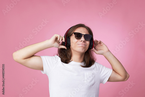 man in sunglasses listens to music with headphones and dances