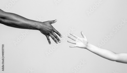 Black and white human hands. African and caucasian hands. Giving a helping hand to another. Helping hand, Rescue, multiathnic people. Helping hands, Rescue gesture. Black and white