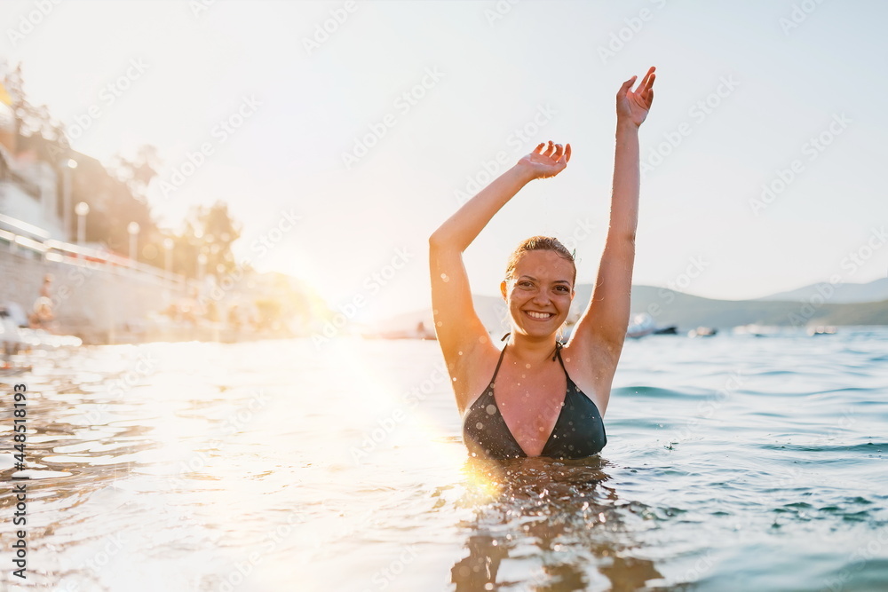a beautiful woman in a swimsuit posing in the sea at sunset a beautiful woman in a swimsuit posing in the sea at sunset