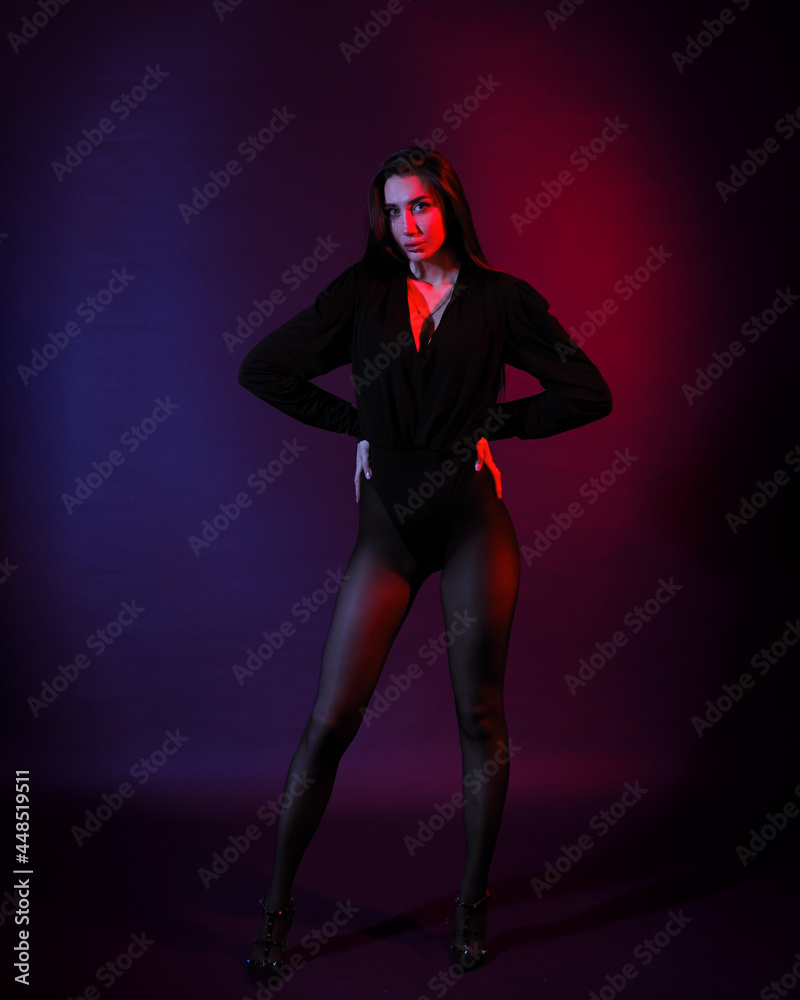 Woman in black bodysuit stands in neon