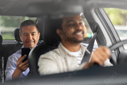 transportation, vehicle and people concept - smiling middle aged male passenger with smartphone on back seat and car driver