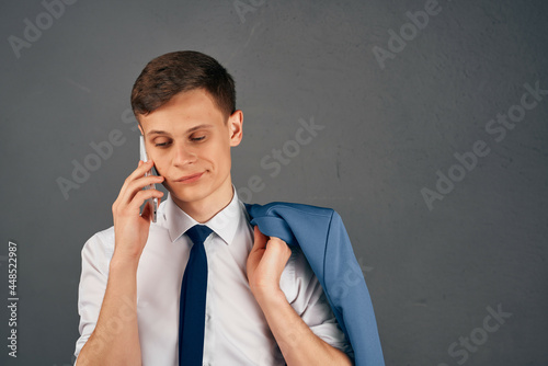 business man with a jacket on his shoulder talking on the phone office manager