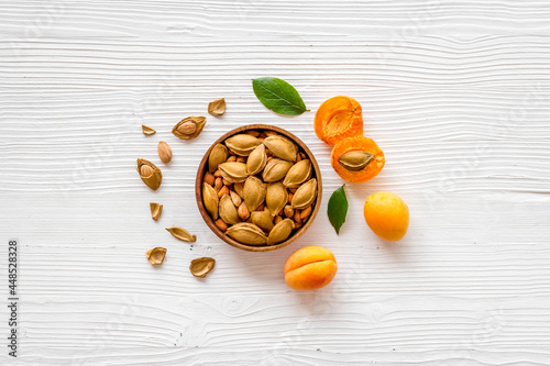 Apricots and apricot pits kernel in bowl. Overhead view