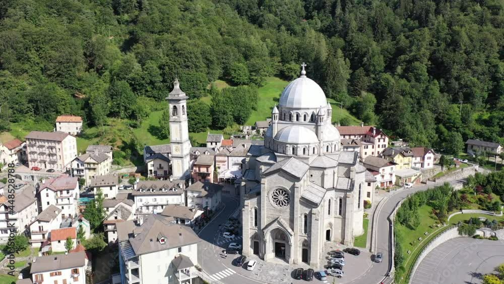 General view of picturesque Re village in green Italian Alps in sunny summer day looking out over pilgrimage Sanctuary of Madonna del Sangue 