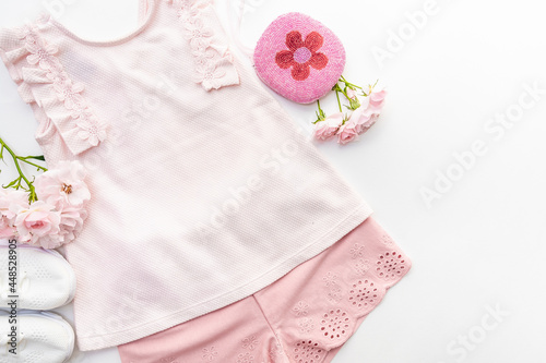 Summer white and pink clothes for a girl, a handbag and sneakers on a white background with copy space © Sergey + Marina