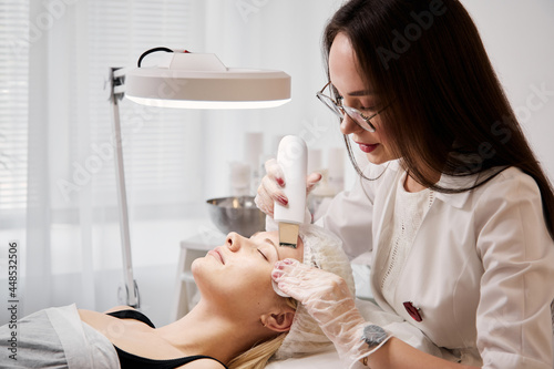 A professional beautician performs a mechanical facial cleansing procedure at the spa. Beautiful caucasian woman on a cosmetic procedure. health Center photo