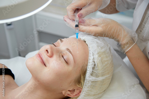 Beautician makes mesotherapy injections. spa beauty treatment, skincare. Woman getting facial care by beautician at spa salon, side view. Wellness center. Healthcare occupation