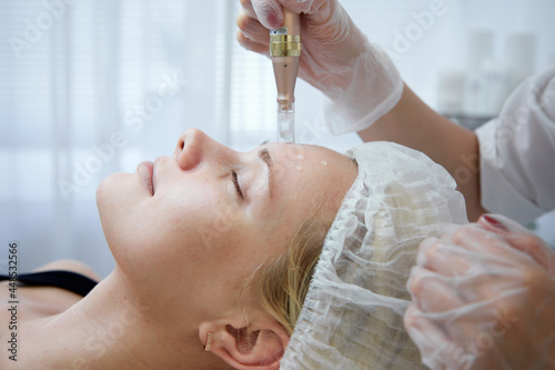 Beautician makes mesotherapy injections. spa beauty treatment, skincare. Woman getting facial care by beautician at spa salon, side view. Wellness center. Healthcare occupation