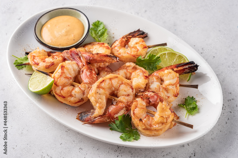 Grilled shrimps. Shrimps skewers, lime and sauce