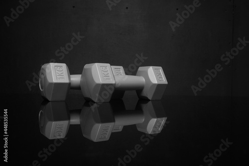 small plastic dumbbells on black background