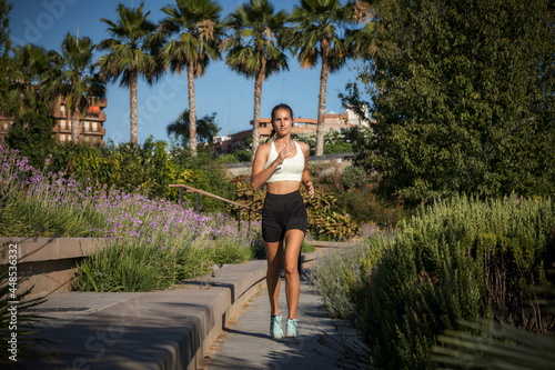 Sporty caucasian girl jogging in a park. Concept runnig