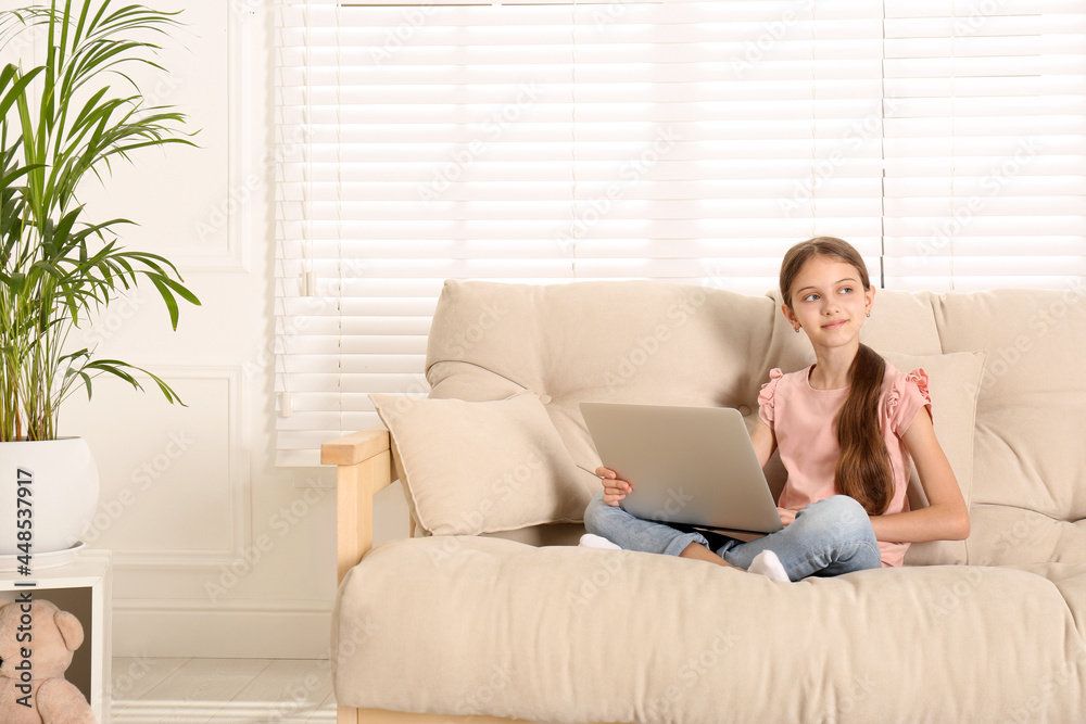 Thoughtful girl with laptop on sofa at home Thoughtful girl with laptop on sofa at home