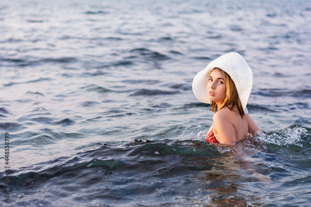 Fototapeta premium Portrait of beautiful young woman traveler in hat and swimsuit on vacation summer vacation