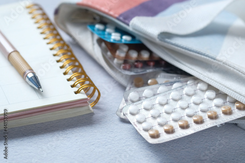 birth control pills in a bag with a planner on table 