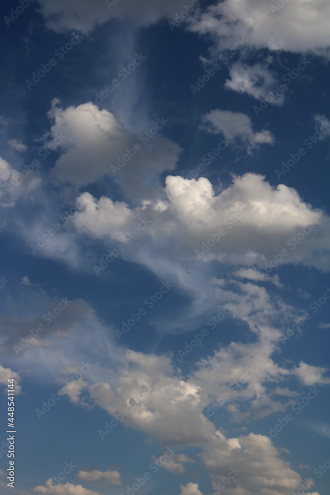 white fluffy clouds on blue sky in summer
