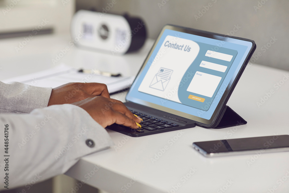 Female customer or online service user entering personal information and email query in Contact Us form on company landing page website. Close up of modern tablet device and hands typing on keyboard - obrazy, fototapety, plakaty 