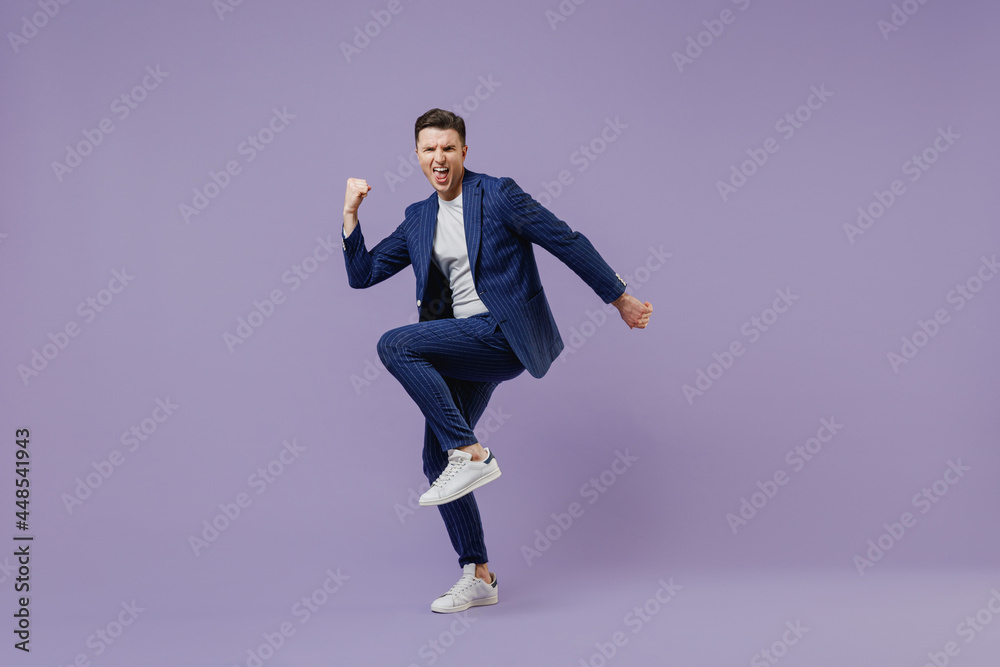 Full size body length young successful employee business man lawyer 20 wear formal blue suit white t-shirt work in office do winner gesture celebrate isolated pastel purple background studio portrait