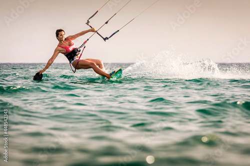 Mujer atlética y hermosa practicando kitesurf en la playa de Tarifa, Provincia de Cádiz, Andalucía, España