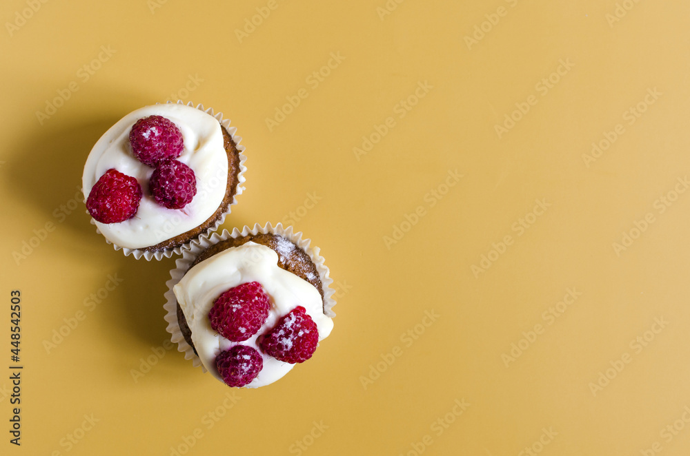 Homemade cupcakes with cream and berries on a colored background. Cake cupcake on a colored background top view is a place for text. Homemade cupcakes with cream and berries on a colored background. Cake cupcake on a colored background top view is a place for text.