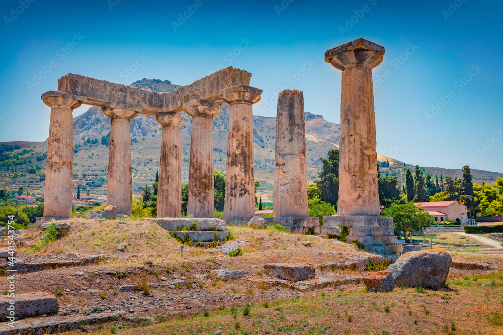 Deep blue sky above remains of an important Roman city - Corinth. Picturesque summer scene of Historical landmark in Greece. Splendid morning cityscape of Archaia Korinthos with ancient columns.