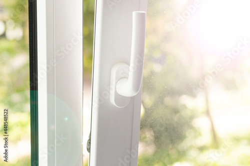 Open plastic white window with bright sun ray light. Dirty windows close up.