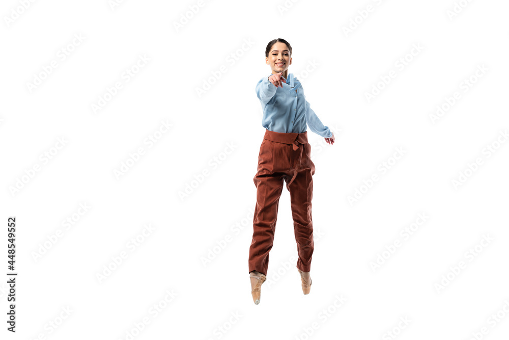 Positive classical dancer pointing with finger while jumping isolated on white Positive classical dancer pointing with finger while jumping isolated on white