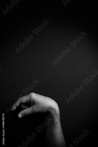 B&W image of hand demonstrating ASL sign language letter Q with empty copy space